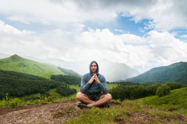 Genç Gezgin, arka planda kayalık dağlarla dışarıda dinleniyor. Yaz tatilleri ve yaşam tarzı yürüyüş konsepti. Kameraya bak.
