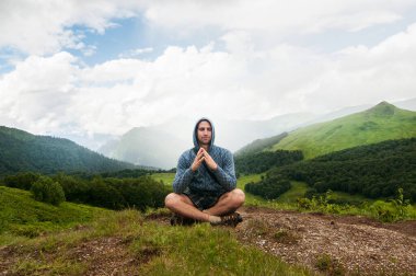 Gezgin adam sakin manzaralı dağlarla meditasyon yapıyor. Seyahat yaşam tarzı yürüyüş konsepti yaz tatilleri