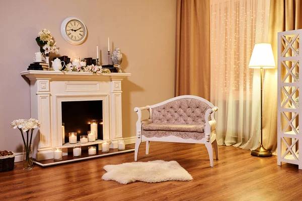 客厅里经典的白色内饰 靠近壁炉的沙发 用鲜花和书本装饰的萤火虫 — 图库照片