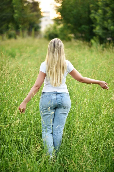 日落时 年轻的女人沿着田野里的小路跑着 自由概念 — 图库照片