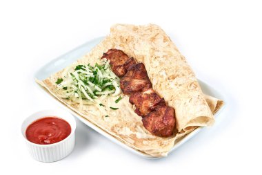 Lokantada soslu şişler. Beyaz bir tabakta soğanlı şişler ve pide ekmeği var..