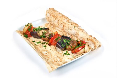 Pişmiş sebzeler bir restoranda beyaz bir tabakta pide ekmeğin üzerinde. Evde kal ve konsepti pişir. Kır yemeği. Manzarayı kapat. Beyaz arkaplanda izole