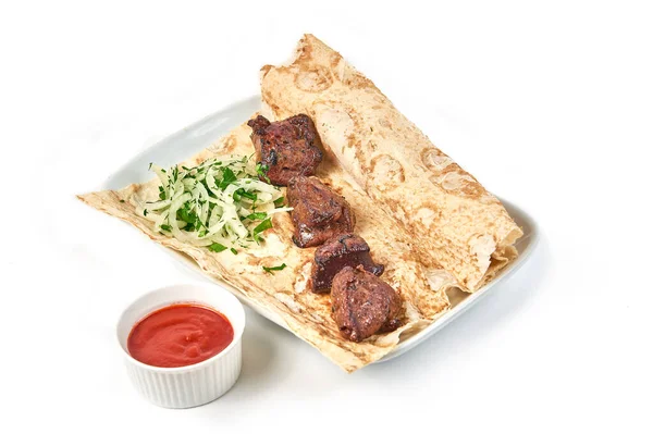 Lokantada soslu sığır ciğeri şişleri. Beyaz bir tabakta soğanlı şişler ve pide ekmeği..