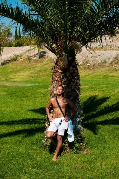 Time to relax and meditation. Man under palm tree.