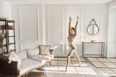 Tam boy yan manzara portresi, esneme hareketleri, sabah antrenmanı, oturma odasında ısınma, yoga ya da pilates egzersizleri, esnek bacaklar. Evde fitness