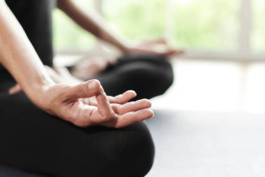 Uyandıktan sonra sabah yogası yapan kadının yakın çekimi. Kolay pozlarda bacak bacak bacak üstüne atmış bir kadın model, Sukhasana duruşu ve meditasyon. Evde antrenman yapıyorum. Motivasyon sağlıklı yaşam konsepti