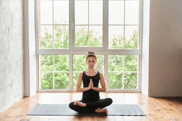 Yogi中年女性半莲花式冥想 无独有偶地在室内全身而退 在有大窗户背景的瑜伽工作室里 健康的生活方式概念 — 图库照片