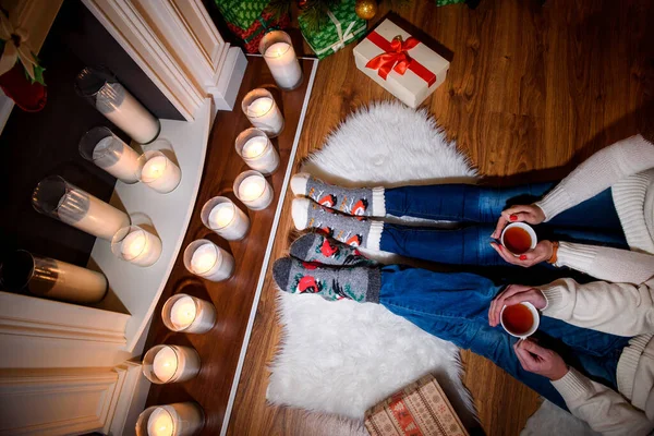 情侣们穿着毛袜 在温暖舒适的壁炉边取暖 — 图库照片