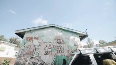 Kisumu, Kenya - 15 Mayıs 2018: Kamera aşağı taşır. Duvardaki etnik resimler ile güzel bir ev. Araba kulübenin duruyor.
