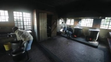Kisumu, Kenya - 15 Mayıs 2018: Grup Afrikalı çocuk büyük bir pot pirinç yıkama. Kız ve erkek kirli mutfakta yemek prepar
