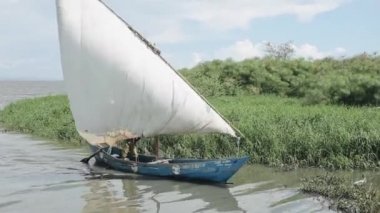Kisumu, Kenya - 16 Mayıs 2018: Afrika adam kirli nehir yoluyla bir yelkenli gemide yola çıkacak. Balıkçı teknede yaz günü Afrika'da çalışıyor..