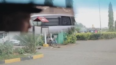 Kisumu, Kenya - 17 Mayıs 2018: Yakın çekim görüntülemek sürücü, Genç adam aynaya yansıtılır. Beyaz erkek Afrika City araba ile seyahat.