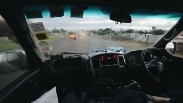 KISUMU, KENYA - 14 MAI 2018 : Vue de l'intérieur de la voiture à travers le pare-brise. Conducteur africain traversant la route de campagne . — Video