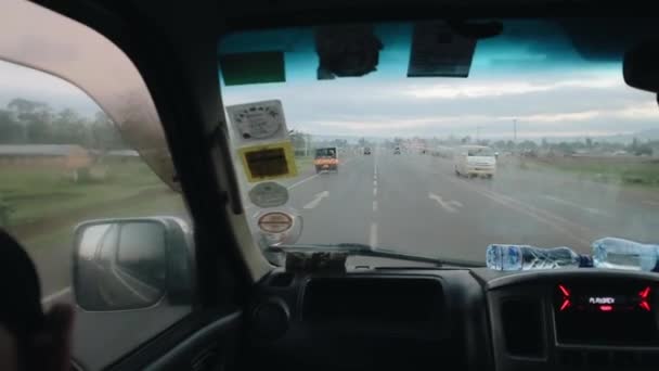 KISUMU, KENIA - 14 DE MAYO DE 2018: Vista desde el interior del coche. Automóvil pasa por la carretera del país en África cerca de auto rickshaw . — Vídeo de stock