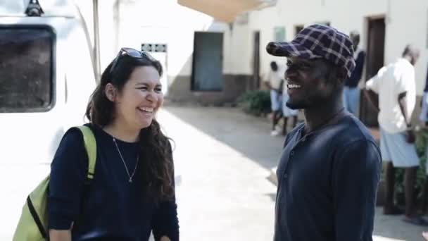 Κισούμου της Κένυας - 15 Μαΐου 2018: Αφρικανική άνθρωπος και καυκάσιος γυναίκα μιλάμε σε ηλιόλουστη μέρα. Ευτυχισμένοι άνθρωποι τη διασκέδαση και το γέλιο. — Αρχείο Βίντεο