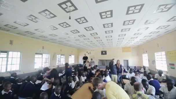 KISUMU, KENYA - 15 MAGGIO 2018: Gruppo di bambini africani e volontari caucasici hanno attività a scuola insieme — Video Stock