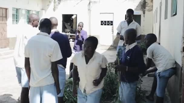 Kisumu, Kenya - 15 maj 2018: Grupp afrikanska barn står utanför nära skolan tillsammans. Pojkar och flickor sortera ut växter. — Stockvideo