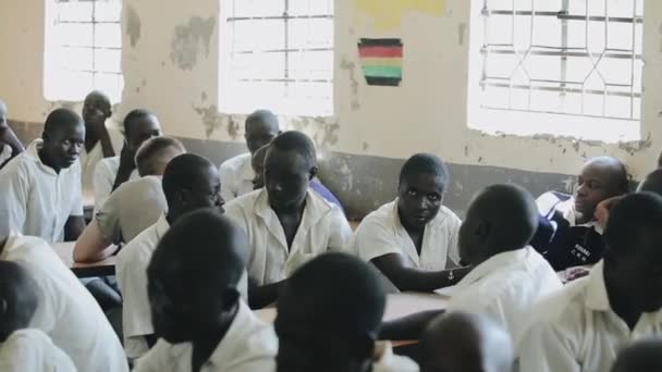 Kisumu, Kenya - 15 Mayıs 2018: Tek tip sınıfta oturuyor ve ders için bekleyen kel Afrika Genç Grup. — Stok video