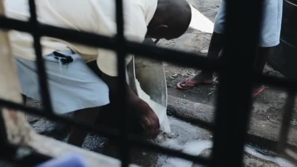 KISUMU,KENYA - MAY 15, 2018: View through lattice. Group of african kids washing rice in pot. Boys and girls prepare food. — Stock Video