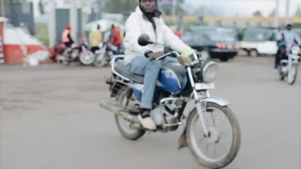 Kisumu, Keňa - 17. května 2018: Pohled z uvnitř auta. Muž na motorce na silnicích v Africe. — Stock video