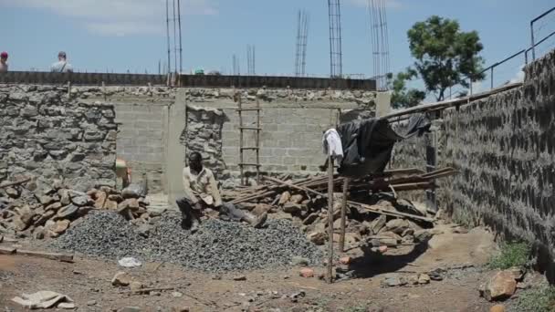 肯尼亚, 基苏姆, 15.05.2018。非洲人在建筑工地工作。夏天的时候, 那家伙正坐在采石场里. — 图库视频影像