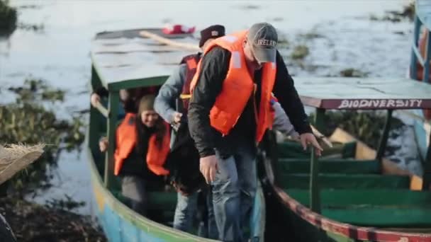 KISUMU, KENYA - 21 Mei 2018: Pria Afrika membantu sekelompok pemuda meninggalkan perahu. Turis di pantai Afrika menjelajahi negara baru . — Stok Video