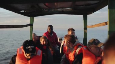 Kisumu, Kenya - 21 Mayıs 2018: Grup beyaz insanlar ve Afrika denizci tekne içinde oturuyor. Turistler Afrika keşfet deniz tarafından.