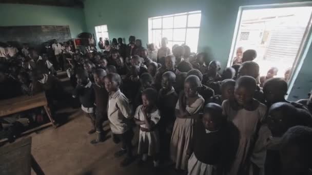 КИСУМУ, Кения - 21 мая 2018 года: толпа африканских детей, стоящих в большом классе. Мальчики и девочки из бедной африканской деревни . — стоковое видео