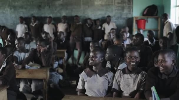 Kisumu, Kenya - 21 Mayıs 2018: Kalabalık mutlu Afrika çocukların okulda. Baylar bayanlar, gençlerin gülümseyin ve gülmek. — Stok video