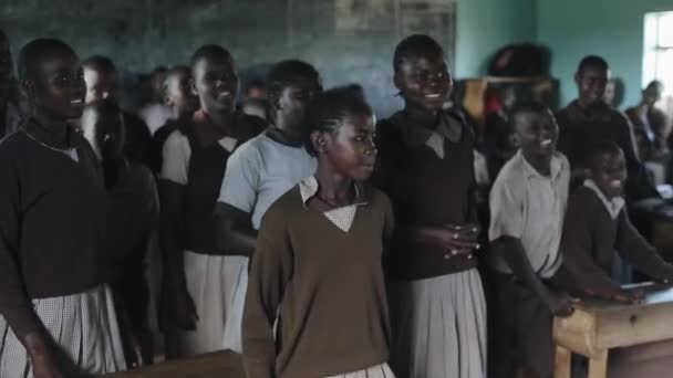 Kisumu, Kenya - 21 maj 2018: Grupp afrikanska barn, tonåringar Dans i stora klassrum, leende och hoppning. — Stockvideo