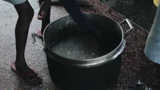 Närbild av afrikanska barnen tvätta riset i en stor pott. Pojkar och flickor matlagning i köket. — Stockvideo