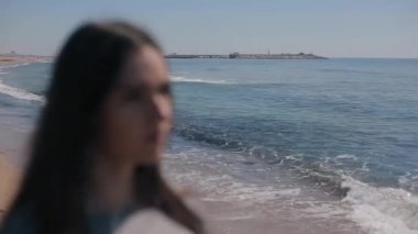 Deniz kıyısına bir bulanık yakın görünümü bir kız. Kadın güneş gözlüğü üzerinde koyarak ve saf vizyon elde