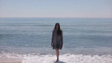 Güzel seksi kız durur, denizden yürür ve kendini tek kolla kucaklıyor. Ağır çekim