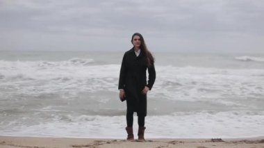Güzel bir kız sahilde bir soğuk rüzgarlı gün ayakta