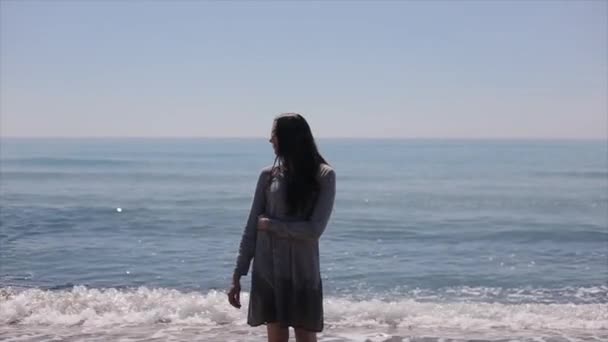 아름 다운 여 자가 서 바다 배경 한 팔으로 자신을 수용 — 비디오