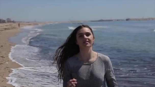 Połowie długości widzenia piękna dziewczyna w mokrej sprawdzane, sukienka taniec na plaży. Zwolnionym tempie — Wideo stockowe