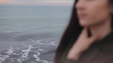 Sunrise güzel denizde. Boynunda bir genç kızın sol elini ile bulanık bakış kapatın. Doğadan kişiye değişen odak