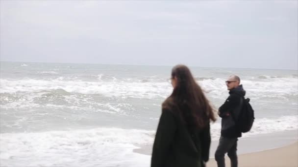 Jonge vrouw en man in de kleren van voorjaar genieten van het Uitzicht van de zee — Stockvideo