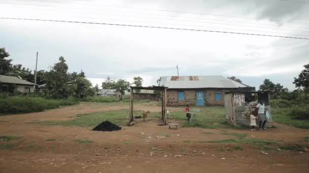 KISUMU, KENYA - 15 de maio de 2018: Povoado africano pobre. As pessoas estão envolvidas em seus assuntos diários, a criança carrega cadeira de plástico . — Vídeo de Stock