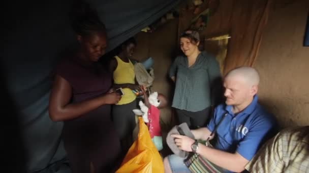 KISUMU, KENYA - MAIO 15, 2018: Grupo de voluntários caucasianos vêm a casa de família africana pobre com presentes para ajudar . — Vídeo de Stock