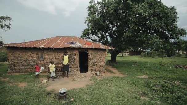 KISUMU, KENYA - 15 de maio de 2018: A pobre família africana está perto de sua casa. Mãe e crianças em uma aldeia na África . — Vídeo de Stock