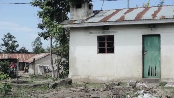 アフリカの貧しい村の小さな家のビュー。ゴミが破壊された建物の周りにあります。. — ストック動画