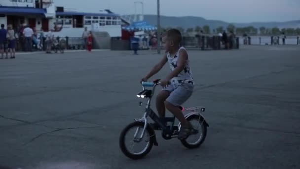 Togliatti. Rusia - uly 3, 2018: Nombre no identificado niño está montando una bicicleta en el muelle — Vídeos de Stock