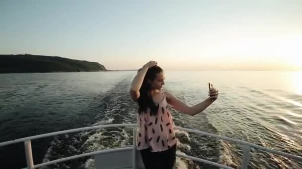 Una hermosa chica hace selfie mientras está de pie en un barco de proa delante de la vista panorámica — Vídeos de Stock