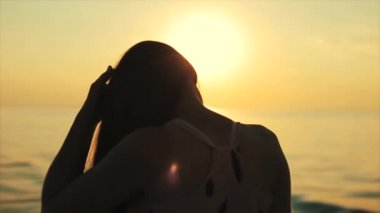 Dikiz deniz gün batımını izlemek güzel bir kız. Ağır çekim. Yakın çekim