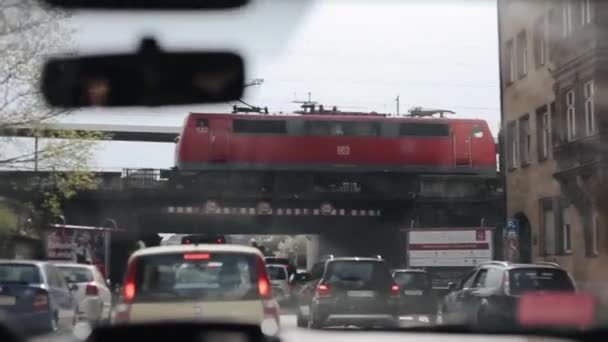 Nürnberg, Tyskland - 23 April 2018: Kör långsamt under en bro en rusningstrafik i en stad i Europa. Visa från inuti en bil. En skylt på ena sidan av vägen — Stockvideo