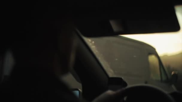 Ένας άνθρωπος τυφλώνεται από ηλιαχτίδες οδηγεί ένα αυτοκίνητο. Πίσω όψη — Αρχείο Βίντεο