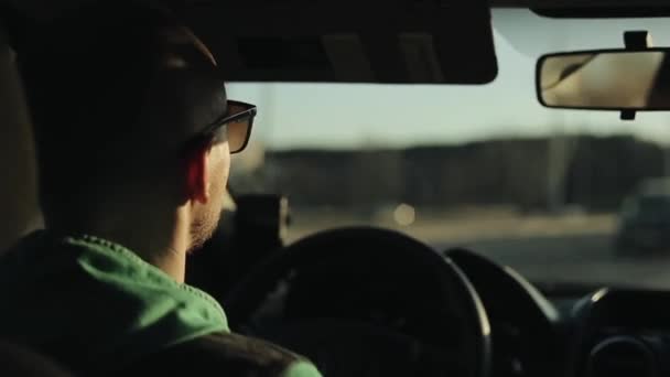 Vista de perto de um homem de óculos de sol dirigindo um carro — Vídeo de Stock