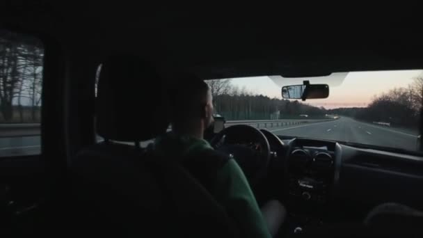 Vista trasera de un hombre conduciendo un coche en la carretera — Vídeo de stock