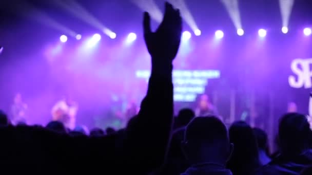 Uma mão erguida num concerto. Palco desfocado. Cantando. Adoração — Vídeo de Stock